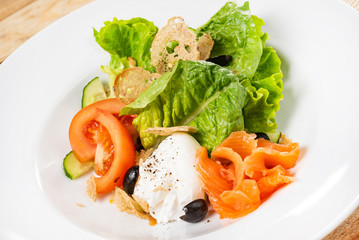 salad with mozzarella and salmon, wooden background