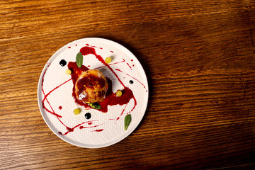 dish of fuagra decorated on black wood table background 