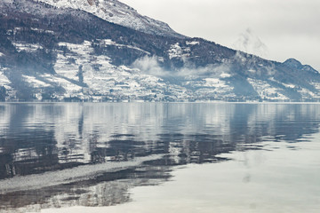 Fog on the water of the Levico lake in Trentino, Italy, seen on a cold winter day.