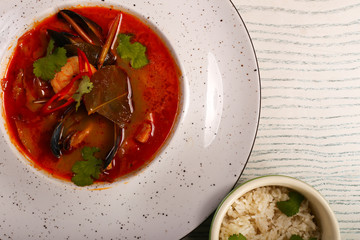 dish of thoam yam soup  on white wood table 