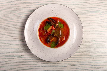 dish of thoam yam soup  on white wood table 