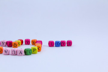 Love alphabet written on colourful wooden block with white background
