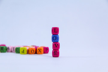Love alphabet written on colourful stack wooden block with white background