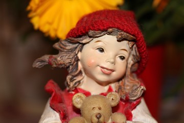 German girl toy in red hat with bear