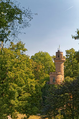 An old, historic defensive tower hidden between trees.