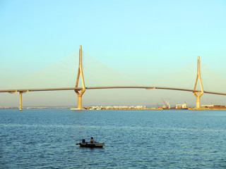 Fishing boats in sunset at the Puente de la Constitución, called La Pepa, in the bay of Cádiz, Andalusia. Spain