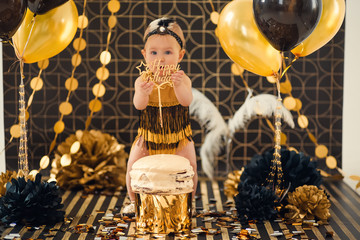 One year old baby girl celebrating her first birthday eating cake