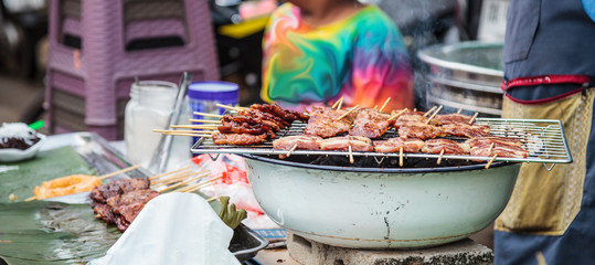 Traditional Street Food Cuisine, Thai Marinated Pork Skewers (Moo Ping, Barbecue Pork Skewers), Grilled with bamboo sticks and often eaten with sticky rice. Thailand Food Travel, Gourmet concept.  