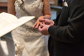 Das Hochzeitspaar tauscht die Ringe während der Zeremonie in der Kirche