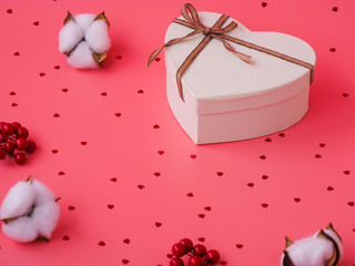 St. Valentine day background. Gift box with gold ribbon and lights on a pink background. Holiday background