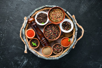 Spices in a wooden box. Colored pepper, sea salt, ground pepper, chili pepper. Top view.