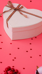 St. Valentine day background. Gift box with gold ribbon and lights on a pink background. Holiday background