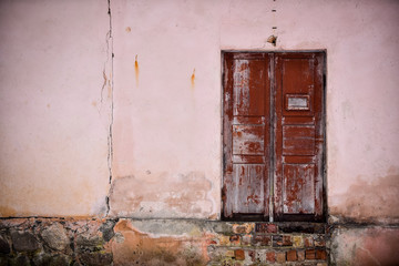 Front of abandoned house with brown wooden  door