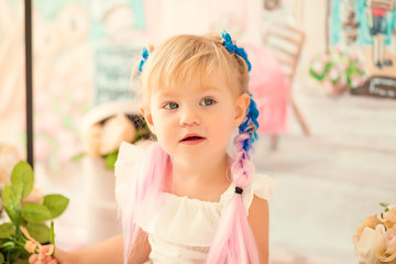 Portrait of a little cheerful birthday girl with the first cake. Eating the first cake. Smash cake.