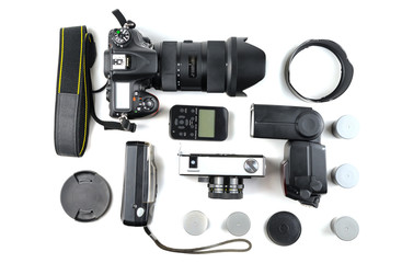 Different generations of cameras and a flash with a sync on a white background