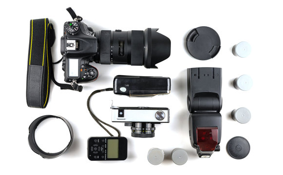 Different generations of cameras and a flash with a sync on a white background