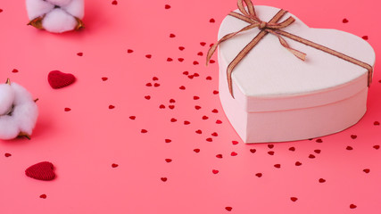 St. Valentine day background. Gift box with gold ribbon and lights on a pink background. Holiday background