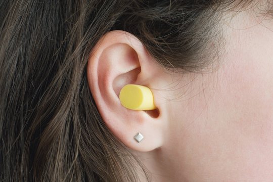 Woman's ear with an ear plug, noice reduce, noice pollution