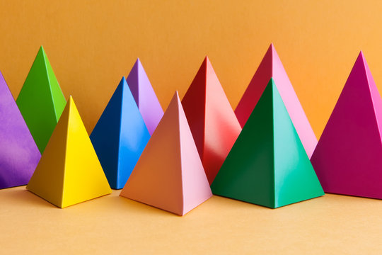 Abstract minimal geometric pattern background with prism pyramid triangle shape figures. Yellow blue pink green violet red colored objects