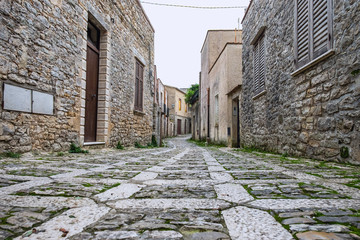 Medieval vintage narrow street with ancient stone pavers with medieval buildings in old european city