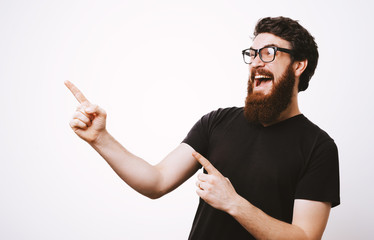 Photo of handsome fancy man wearing black t-shirt having fun and pointing fingers away meaning hey...