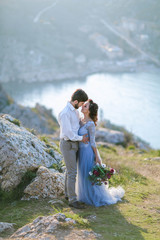 Wedding couple in love kissing and hugging near rocks on beautiful landscape.