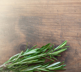 Rosemary herb bound on a wooden background with copy space. Fresh rosemary. Top view.