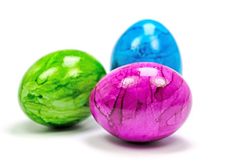 Drei gefärbte Hühnereier vor weißem Hintergrund