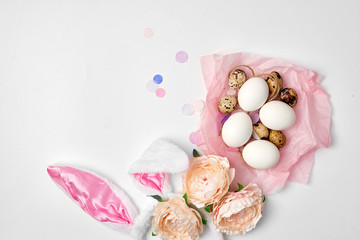 Quail and chicken eggs in a pink paper nest on the white isolated background Easter farm concept copy space