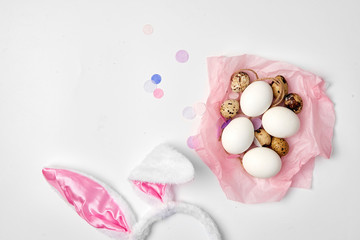 Fototapeta na wymiar Quail and chicken eggs in a pink paper nest on the white isolated background Easter farm concept copy space