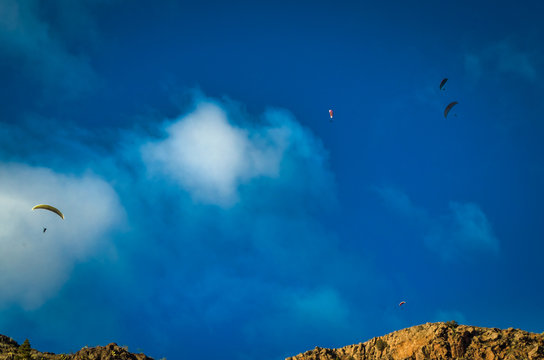 Paragliders over a mountain ridge