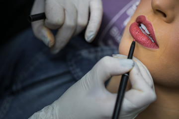 Maquiadoras passando batom no l&aacute;bio de mulheres, deixando a maquiagem ainda melhor