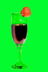 A glass of red homemade wine with strawberries on a green background