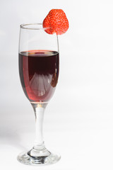 A glass of red wine with strawberries on a white background