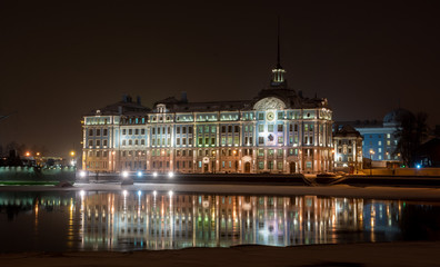 Fototapeta na wymiar Nakhimov Naval School building with night illumination and its reflection in the winter river, St. Petersburg 