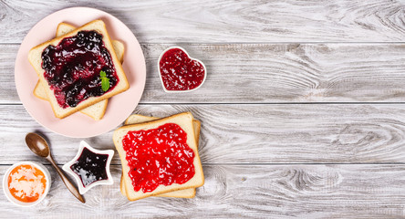 Delicious toasts with various sweet jams on grey background. Copyspace for your text, banner.