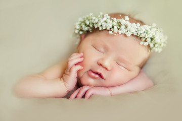 Newborn baby girl posing in tutu skirt and flower head band