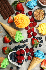 Vanilla frozen yogurt or colorful soft ice cream in waffle cone.