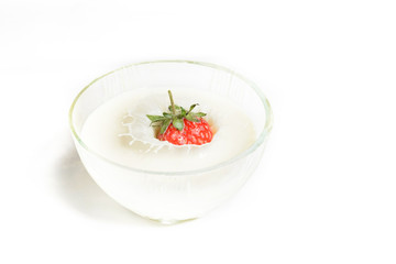 Splashes into a cup of milk with strawberries.