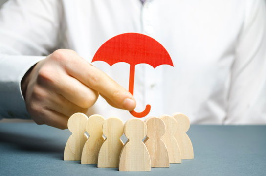 Boss holding a red umbrella and defending his team with a gesture of protection. Life insurance. Customer care, care for employees. Security and safety in a business team. Selective focus