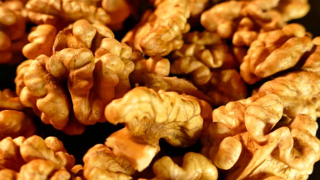 Walnut closeup. Nuts without shell on a black background. Kernels scattered on the table.