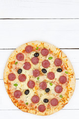 Pizza Pepperoni Peperoni Salami Hochformat Textfreiraum Copyspace von oben auf Holzbrett