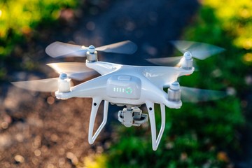 White drone quadrocopter in flight.