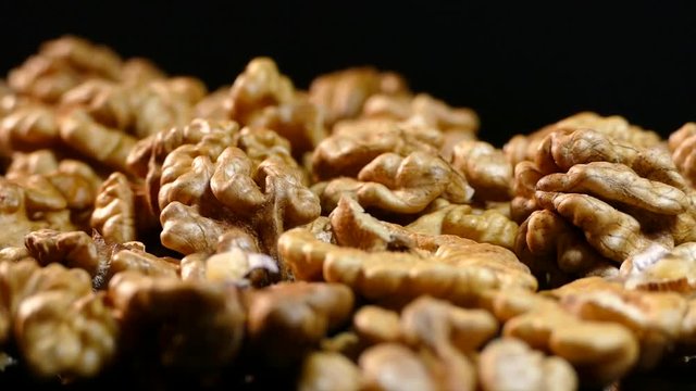 Walnut closeup. Nuts without shell on a black background. Kernels scattered on the table.