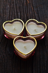 Heart shaped candles on a dark wooden background