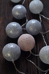 Cotton balls lights on a dark wooden background