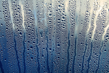 Texture of rain drops on a glass wet transparent surface.