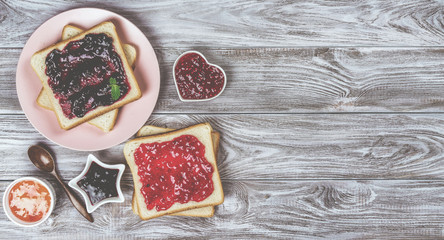 Delicious toasts with various sweet jams on grey background. Copyspace for your text, banner.