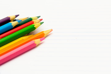 Fototapeta premium Colored pencils with light background. Back to school. School material for learning. Space for text