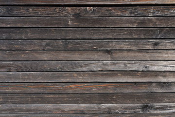 Surface of a heavily weathered planking of a facade made of wooden slats